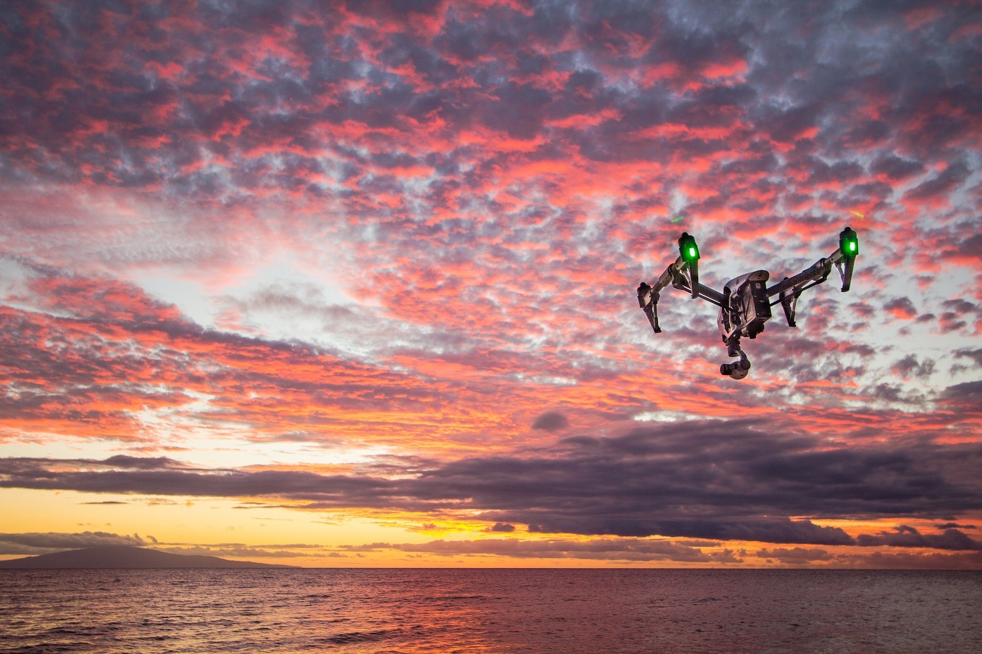 A drone flying against a sunset