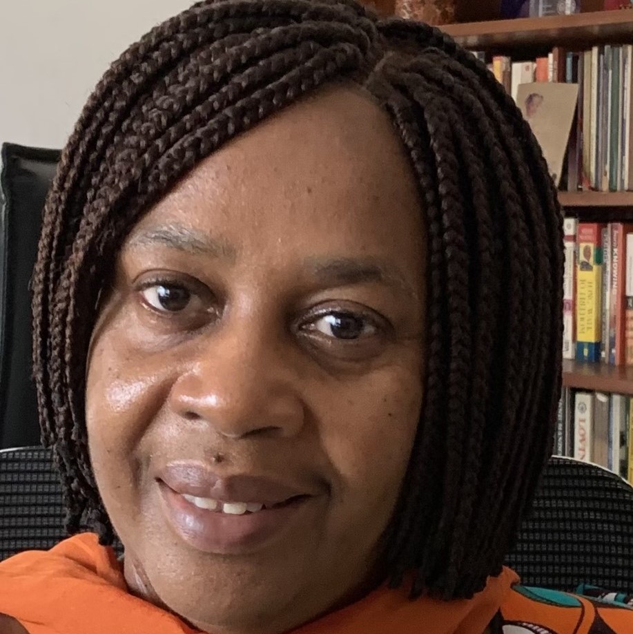 Photo of Abena Oduro, looking into the camera with a bookshelf in background