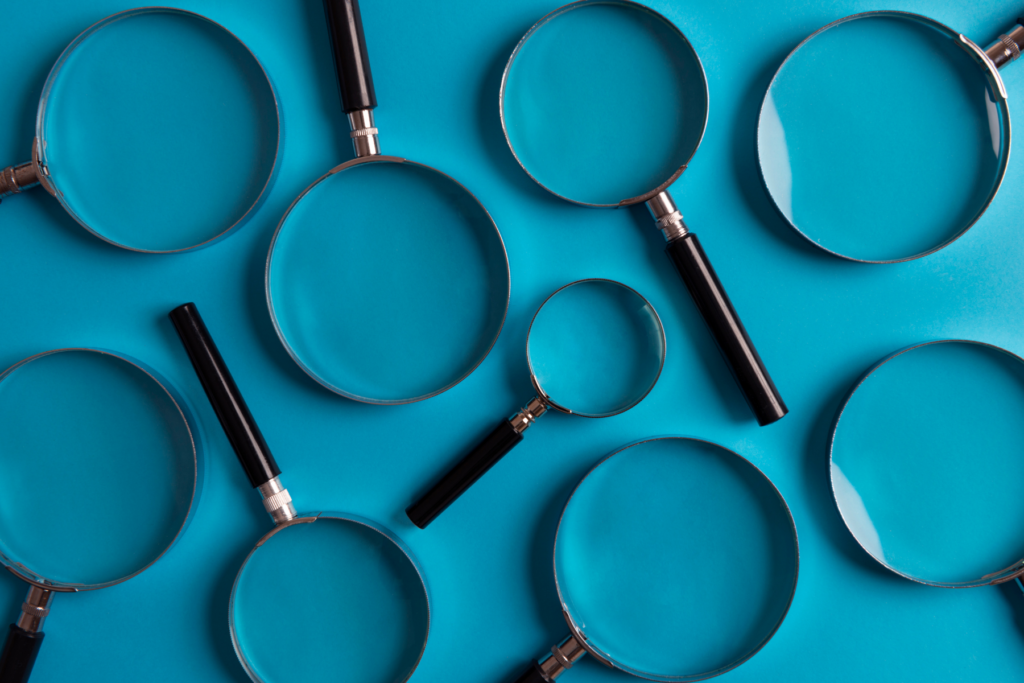 Magnifying glasses of differing sizes against a teal background