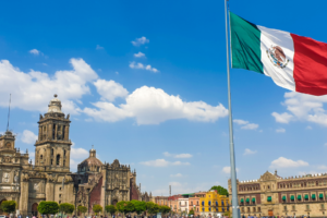 Image of Metropolitan Cathedral in Mexico City with a Mexican flag blowing in the wind