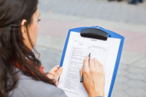 Woman filling out survey on clipboard