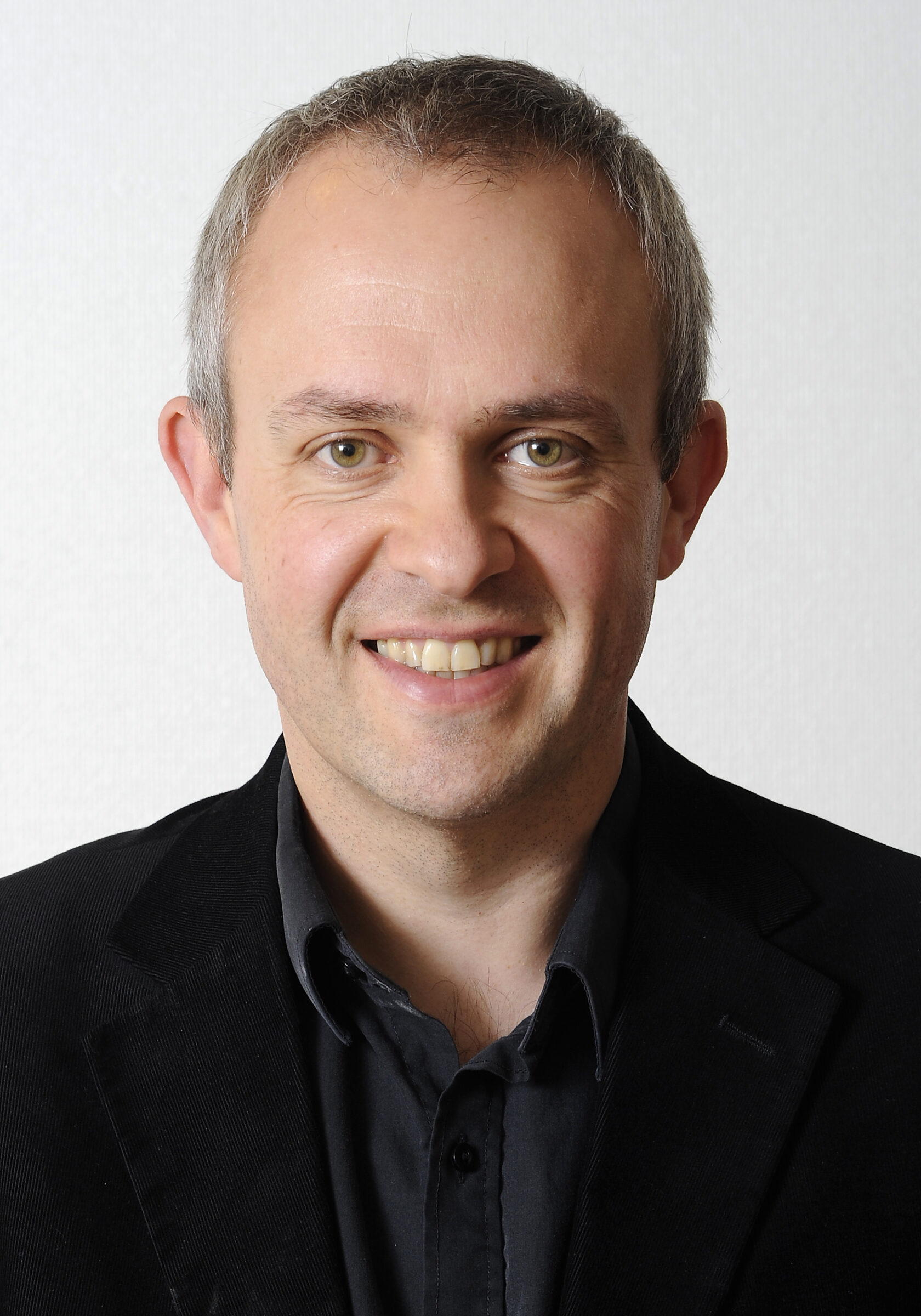 Current joint Editor of Europe Asia Studies Journal Professor David J. Smith is wearing a dark collared shirt and smiling