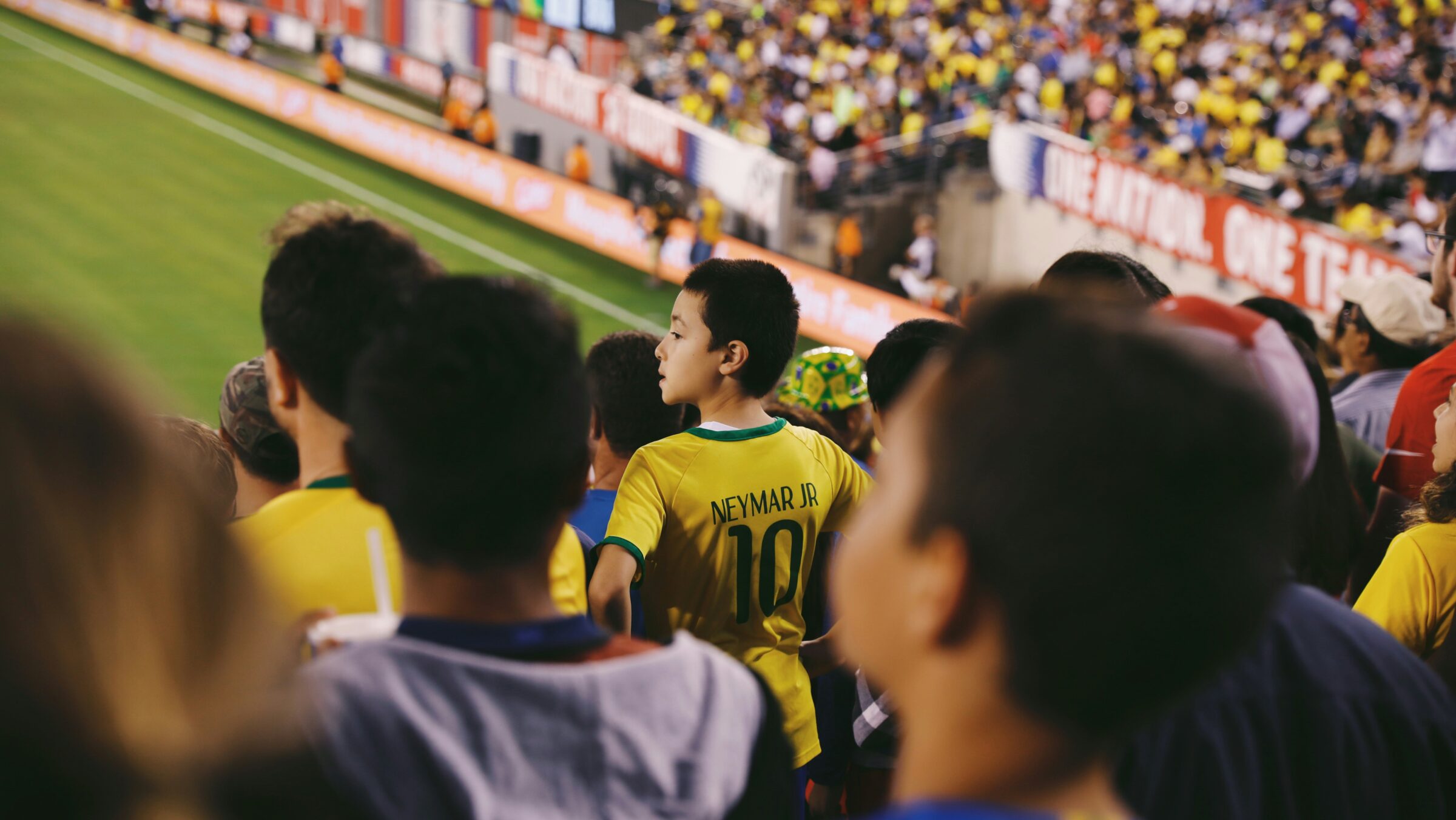 crowd at sport game with boy wearing soccer jersey